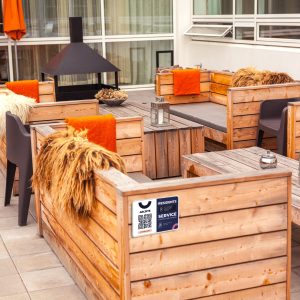 Outdoor restaurant terrace with wooden furniture in scandinavian style. Eco-friendly authentic design.