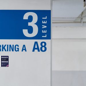 Signage on the indoor carparking pole, tell driver which way to go and location in parking lot.